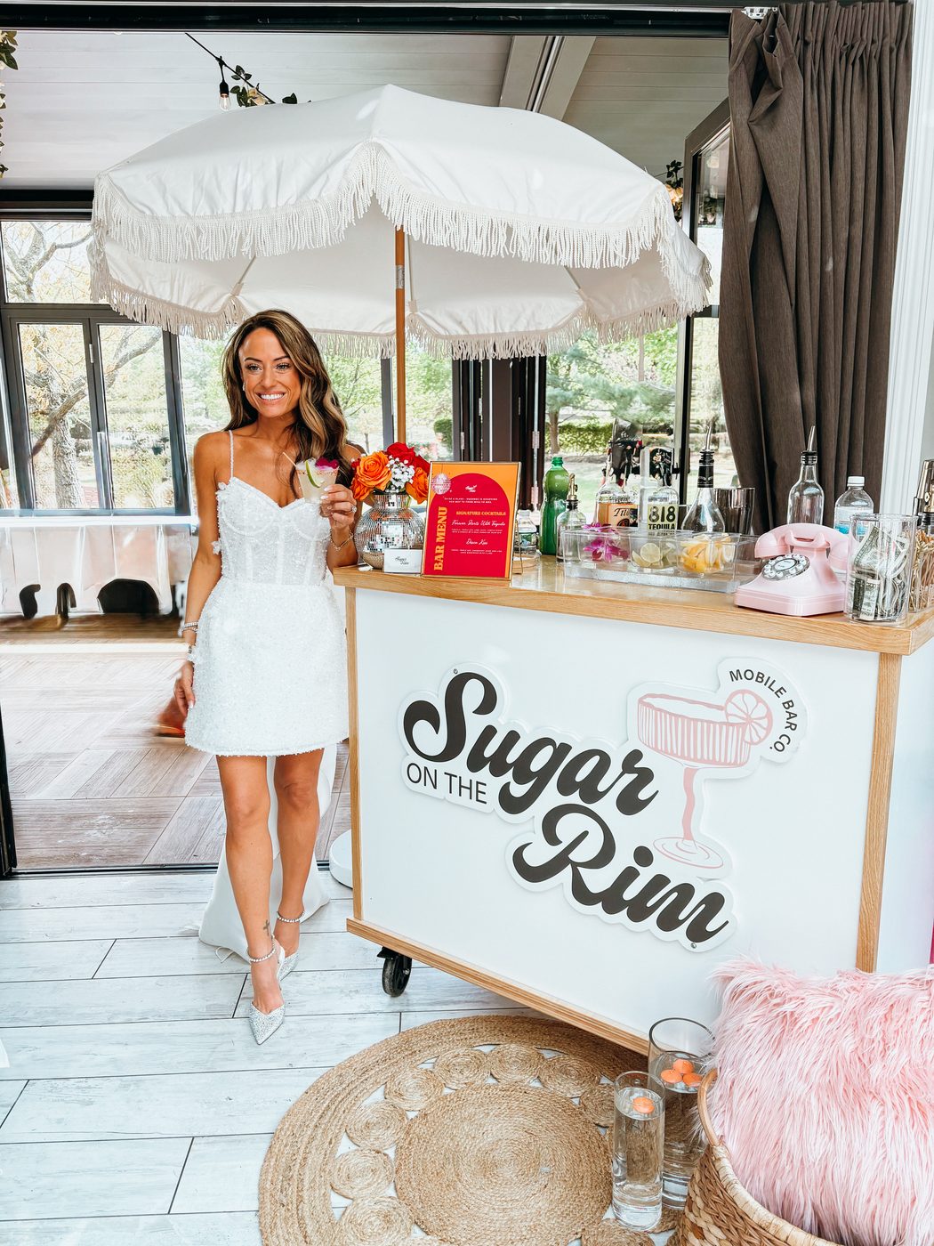 Guest in a white dress at a styled Sugar On The Rim cocktail bar