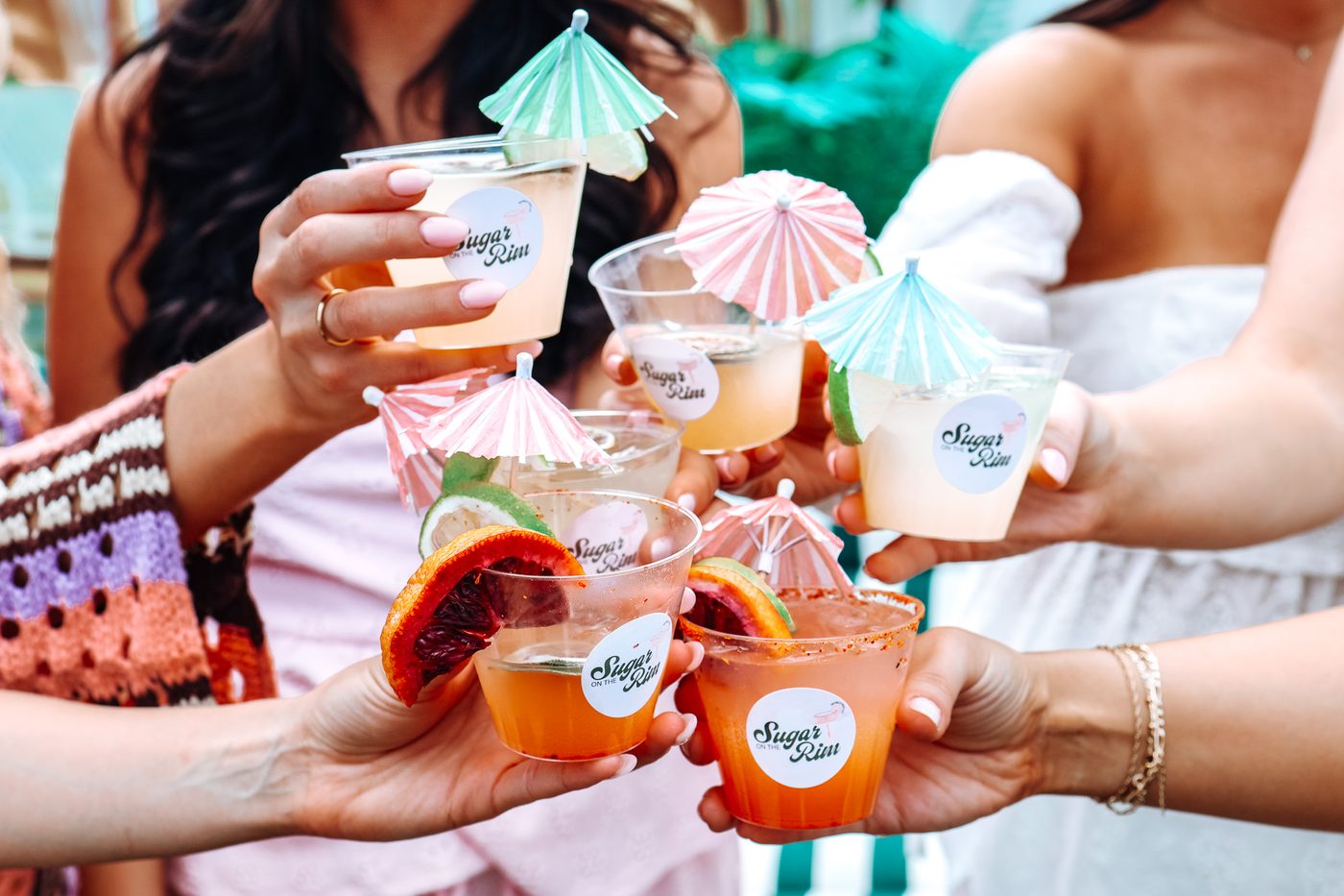 Guests toasting colorful cocktails with paper umbrellas